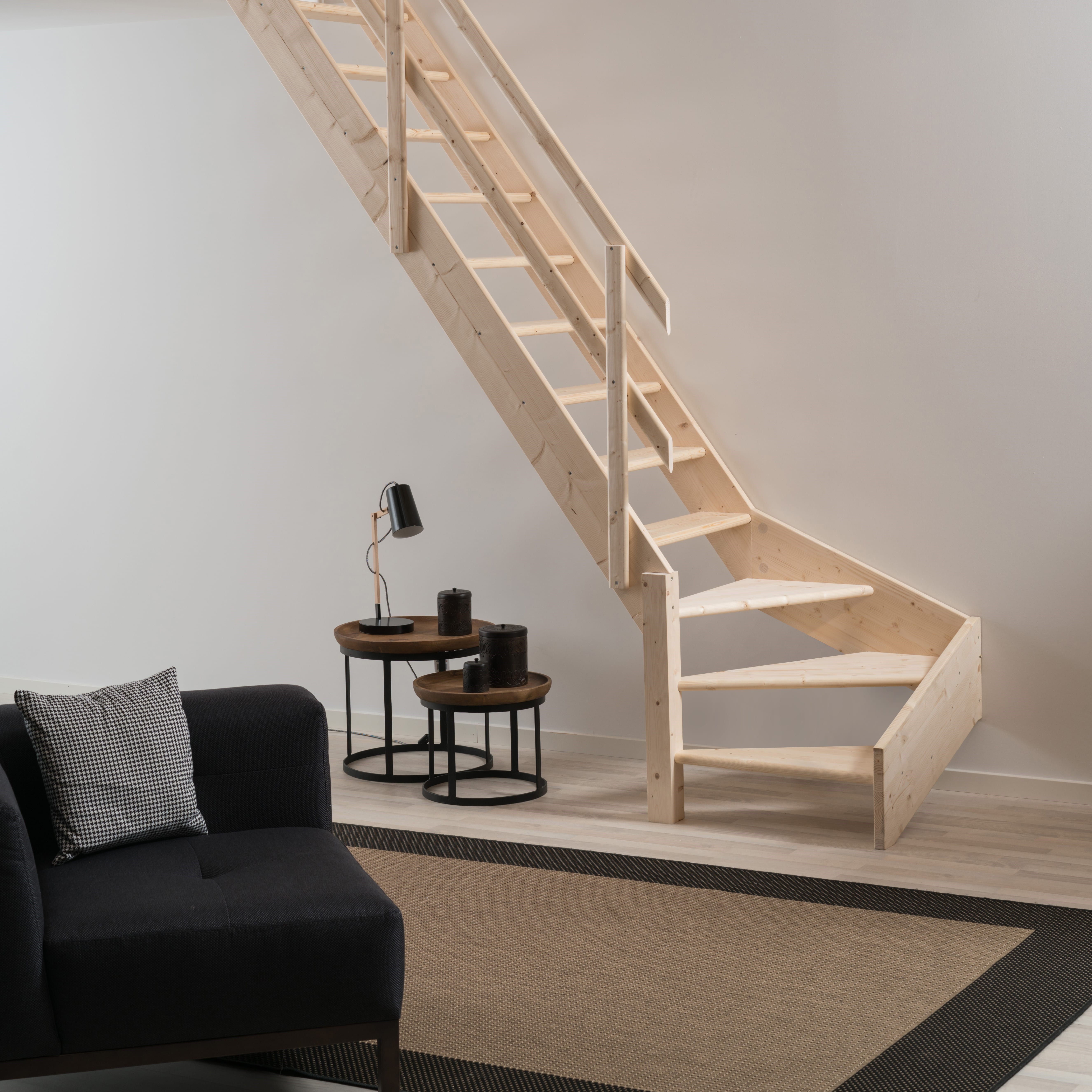 Minimalistische houten NORMANDIE trap met strakke lijnen in een moderne en lichte woonkamer.