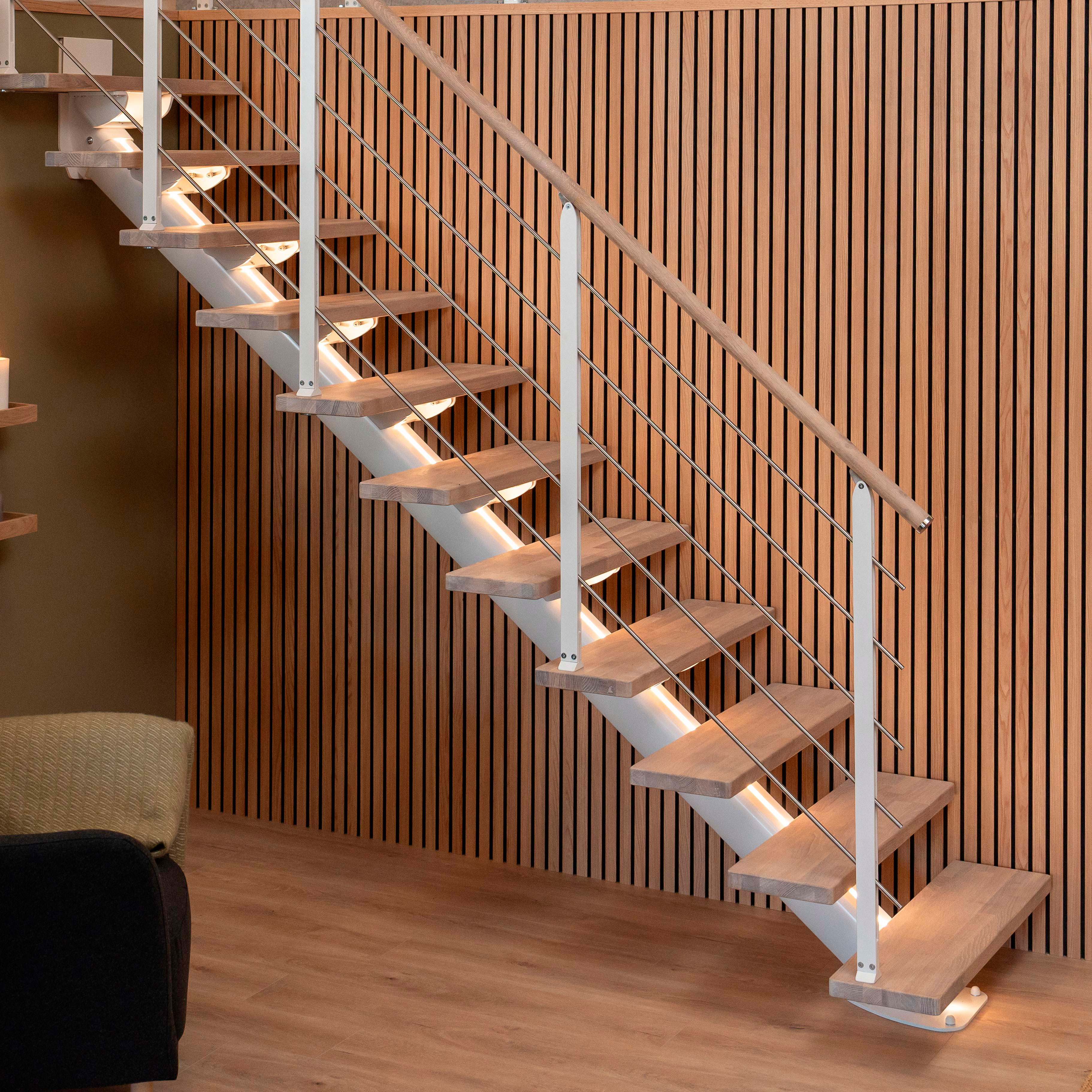 SYDNEY trap met houten treden, metalen leuningen en warme verlichting tegen een houten muur.